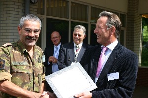 Lt. Col. Edwin Saiboo, RNLA, head of the Knowledge Center for Command and Control (l), accepts a token of thanks from Cdre. Schoonderbeek after the June meeting.